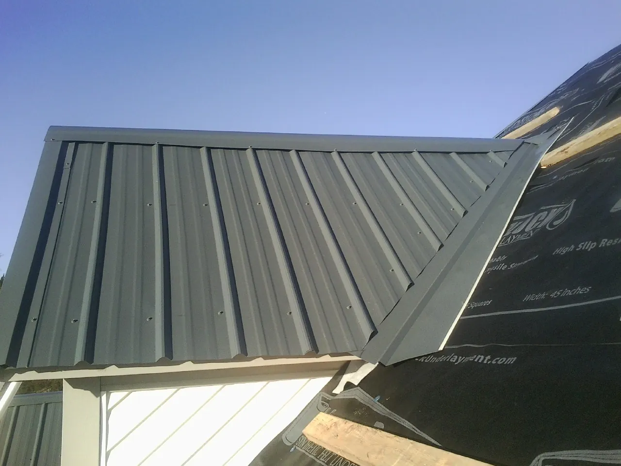 Gray metal roof panels going on over a garage gable in Cuba