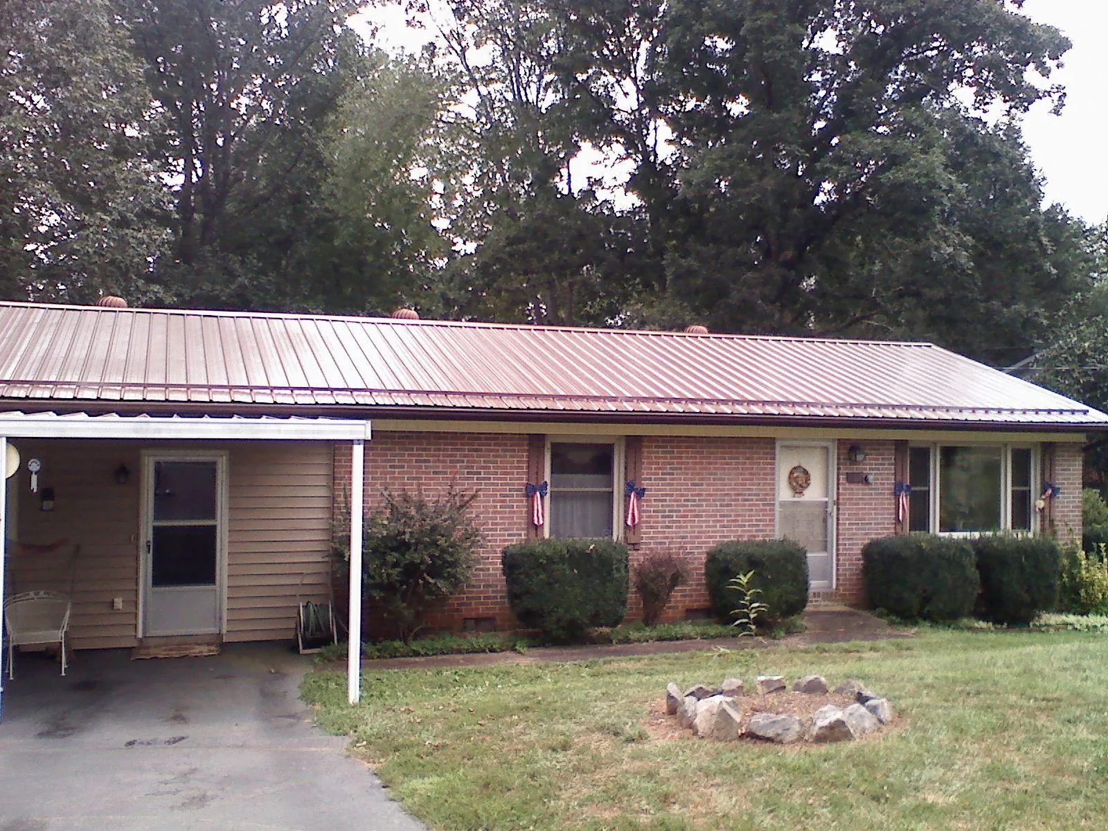Bronze metal roof and carport on a brick ranch home — Roof Repair work by our crew in Cuba